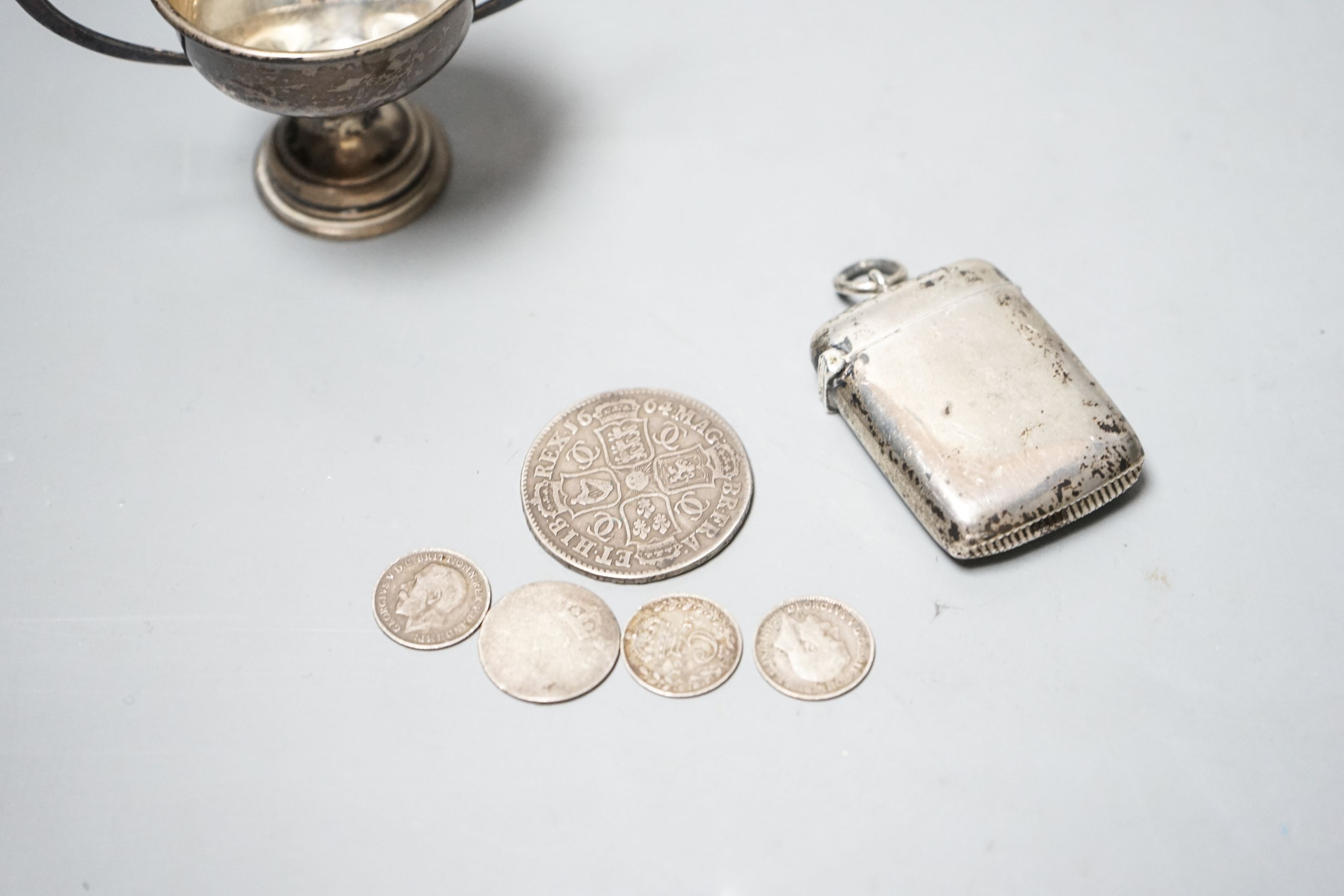 A silver vesta case, a small silver trophy cup and five assorted coins including a Charles II half crown, 1664.